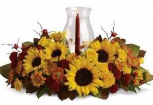 Red candle in center of sunflowers
