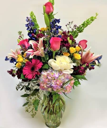 Liven up their day, Brighten up her day, Send a fragrant and elegant vase of filled with Spring Blooms. Capture their heart with this elegant arrangement of roses, hydrangeas, fragrant stargazer lilies, stock, delphiniums and bells of Ireland hand-delivered with love in a clear glass vase. This elegant and graceful arrangement is sure to amaze.