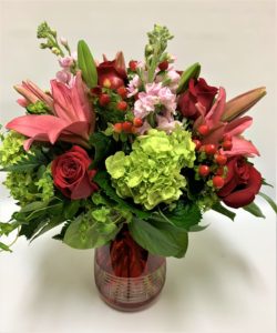 WOW! An amazing expression of love expressed by this romantic arrangment for your special someone. Red roses, pink lilies, green hydragneas, fragratn stock and hypericum are nestled amidst bluperumin a modern keepsake red glass vase. Send this arrangement to that special someone to know they are love.