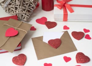 Brown envelopes with white letters inside and sparkly red hearts.